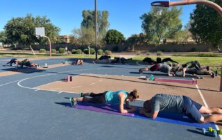 A group of people doing yoga on the ground.