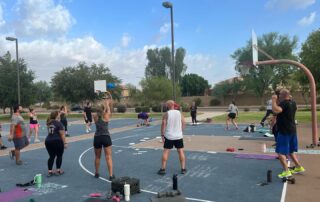 A group of people standing on top of a basketball court.