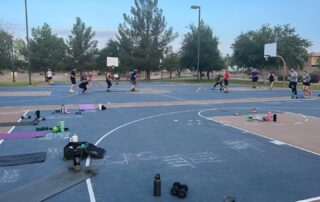 A group of people are on the court doing different exercises.