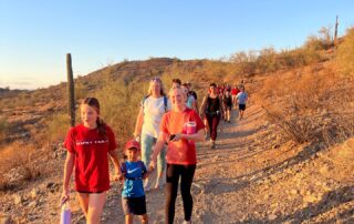 A group of people walking on the side of a hill.