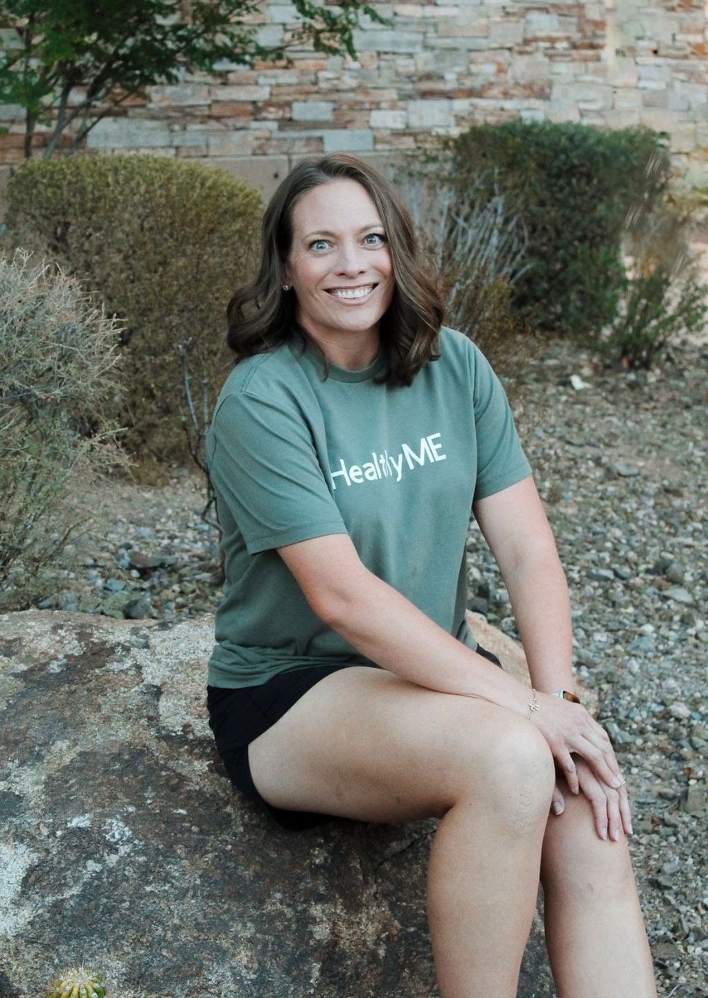 Woman smiling in green "Healthy Me" shirt.