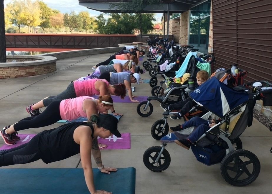 Women doing push ups with baby strollers.